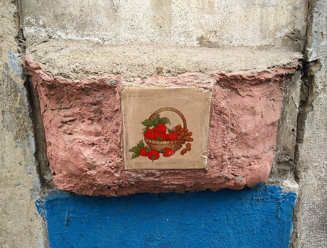 Ada Wanders/Włóczykijada. The tile with a picture of a basket with fruits on the wall in Alfama in Lisbon.