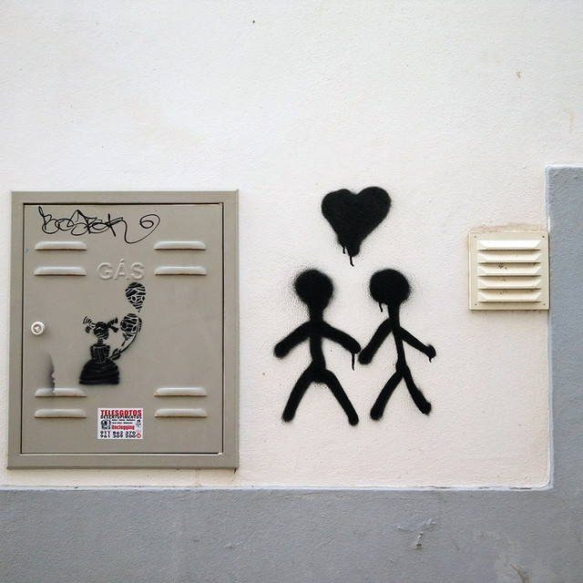 Ada Wanders/Włóczykijada. Street Art in Lagos. Sticky figures with heart and a girl with gas masks.