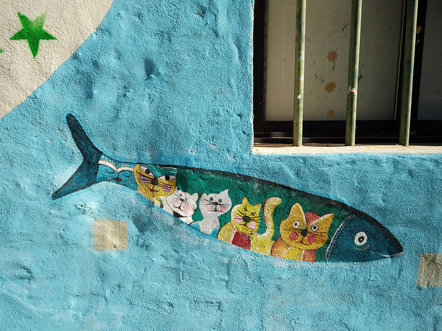 Ada Wanders/Włóczykijada. Street Art: Picture of fish with cats inside in Portimão